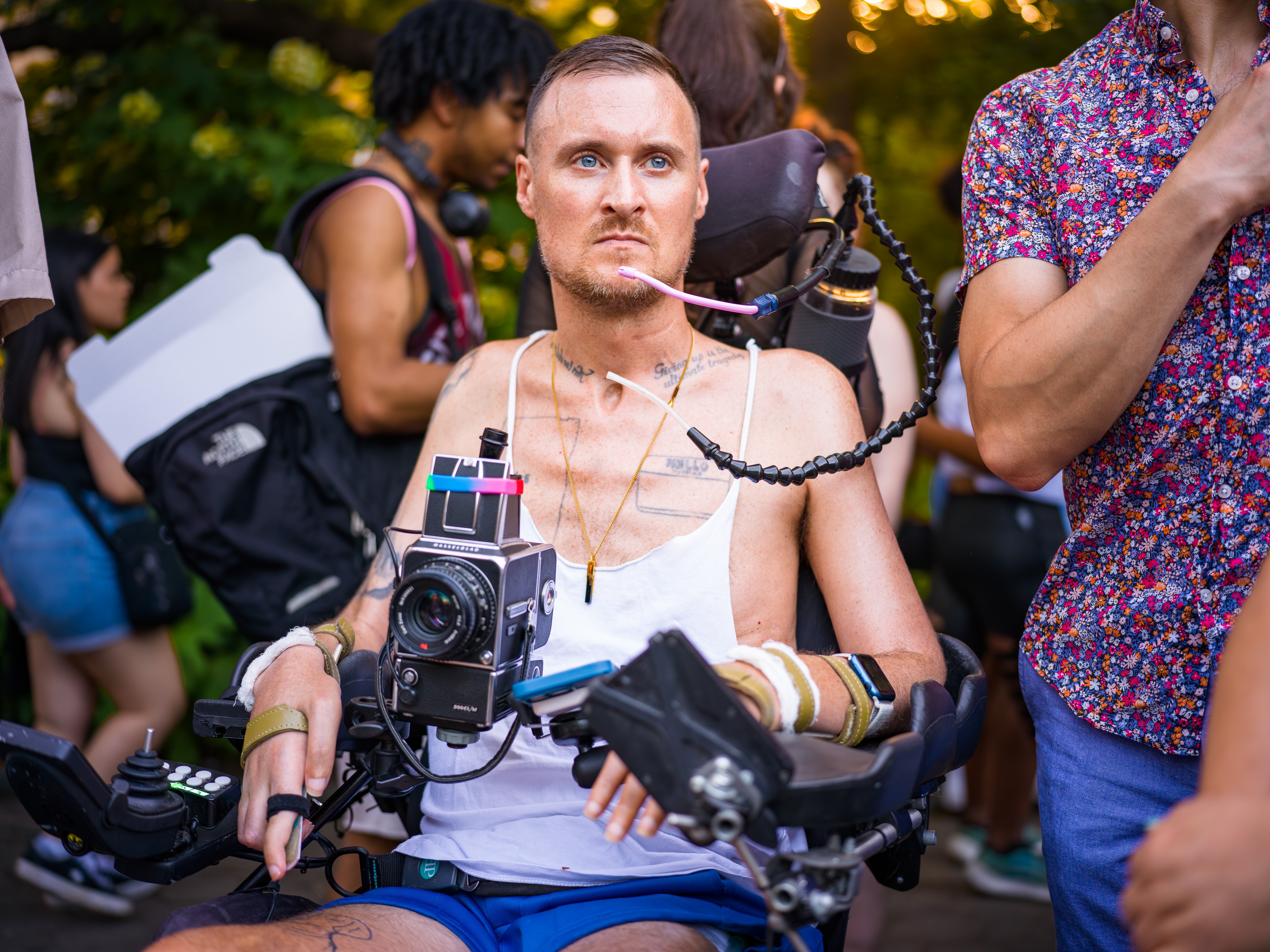 Robert Andy Coombs seated in his power wheelchair with a medium-format camera mounted in front of him.